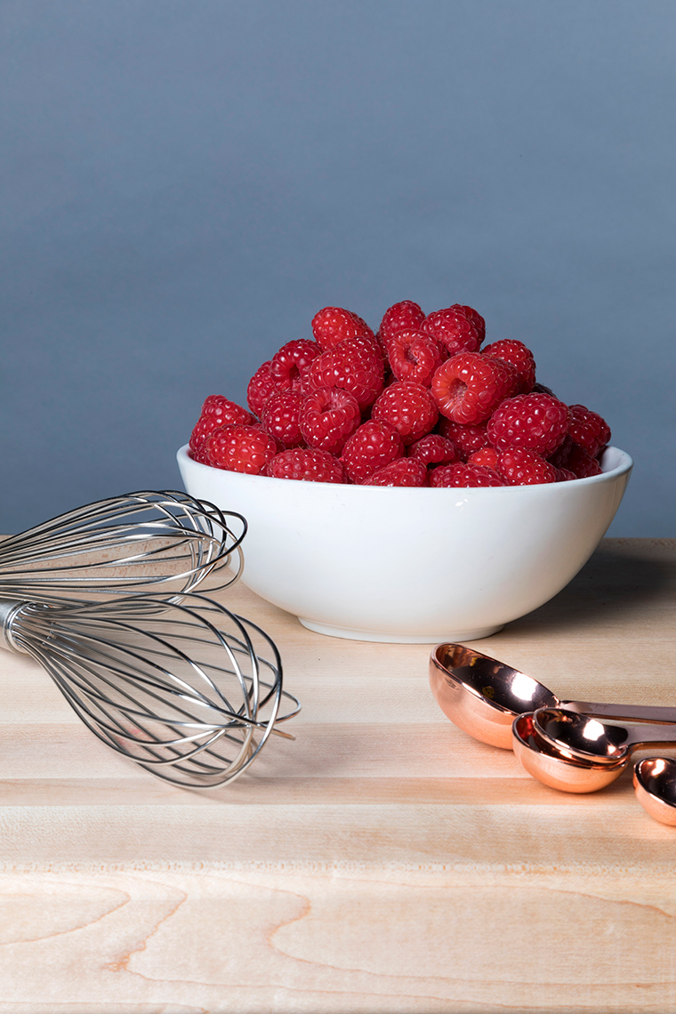 Raspberries in a ceramic white bowl.