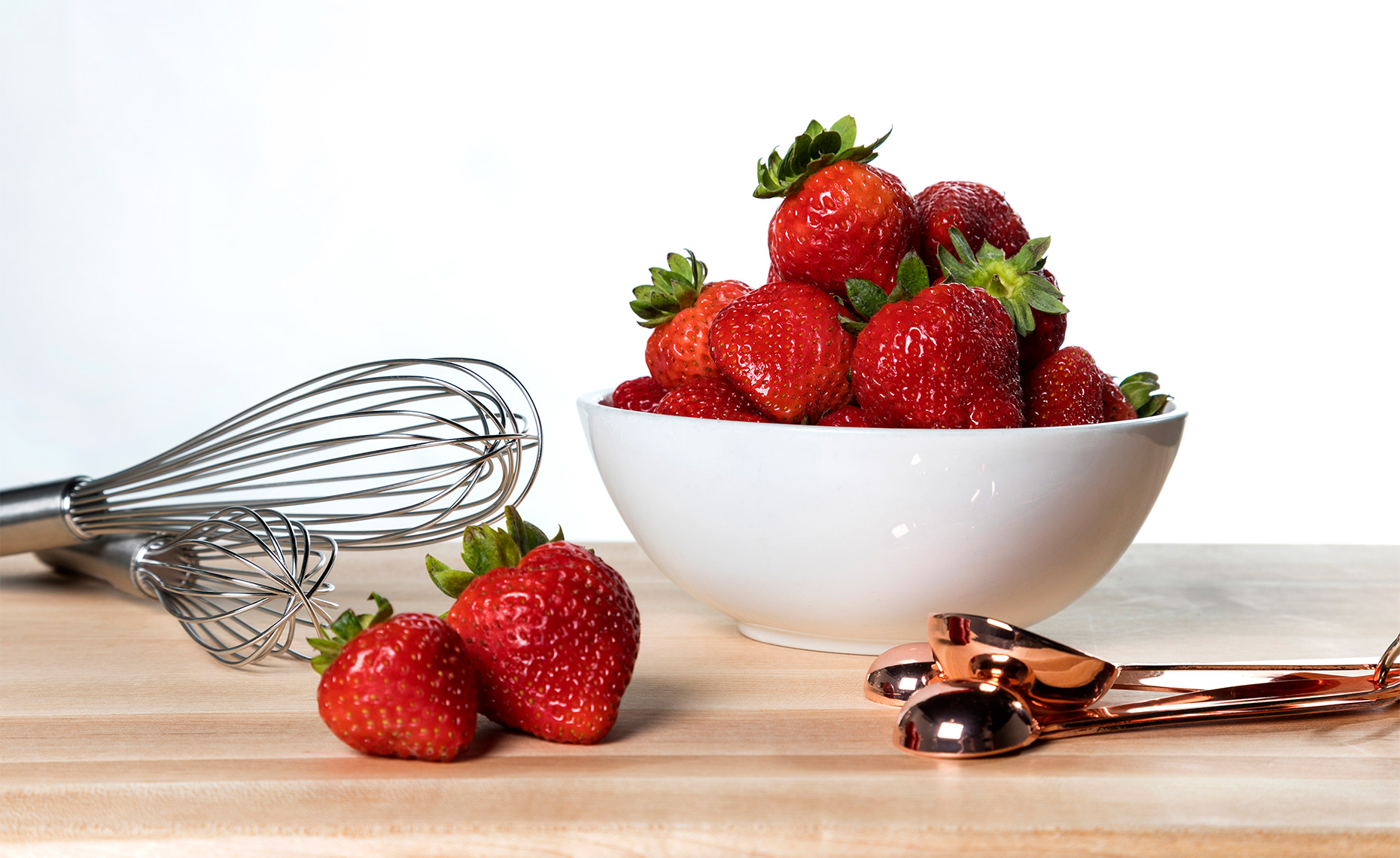 Strawberries in a ceramic white bowl.