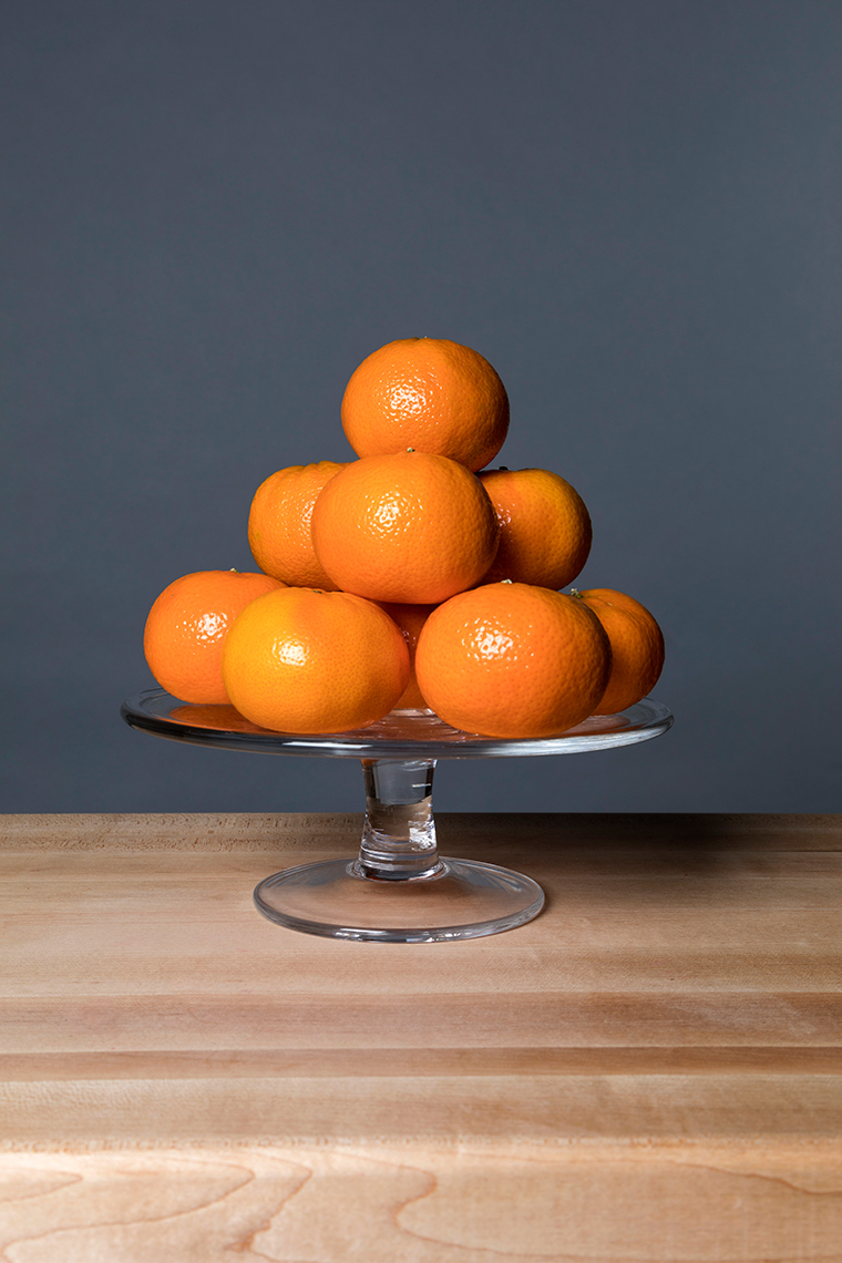 Tangerines on a glass stand.